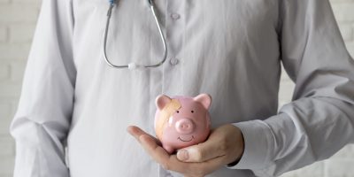 médecin avec une tirelire cochon